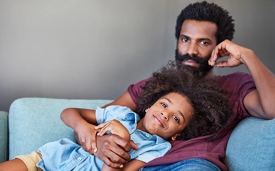 Father and daughter relaxing on a sofa