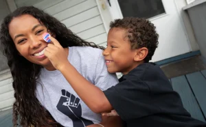 Child puts sticker on woman