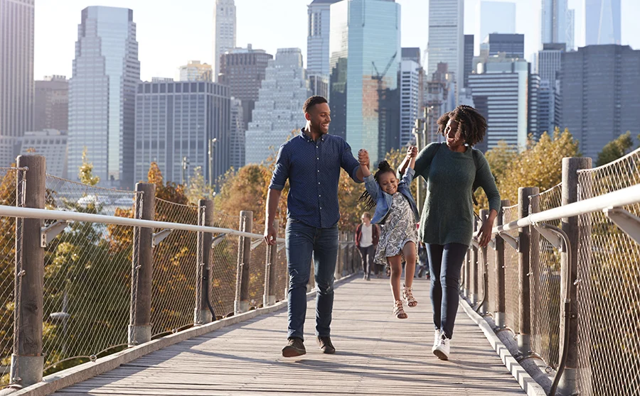 Young family with daughter taking a walk on footbridge