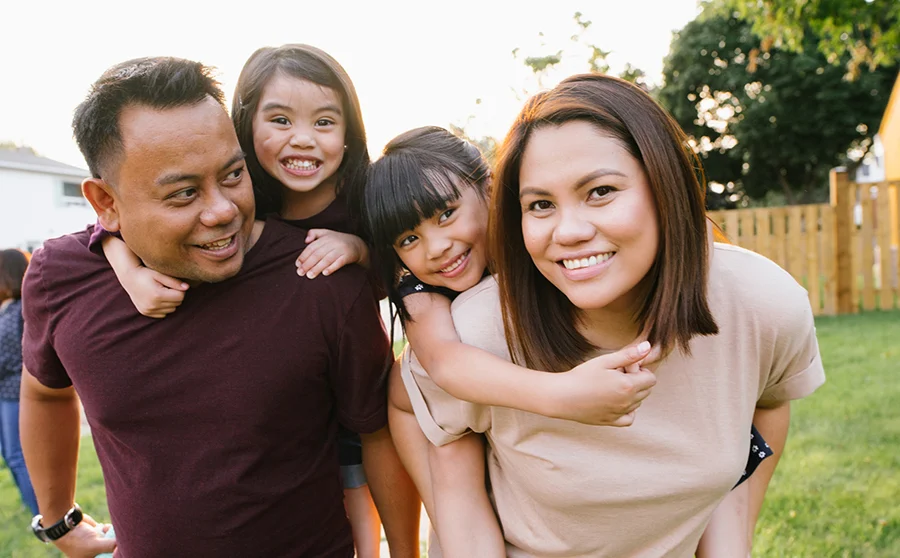 Smiling family outdoor with two little kids