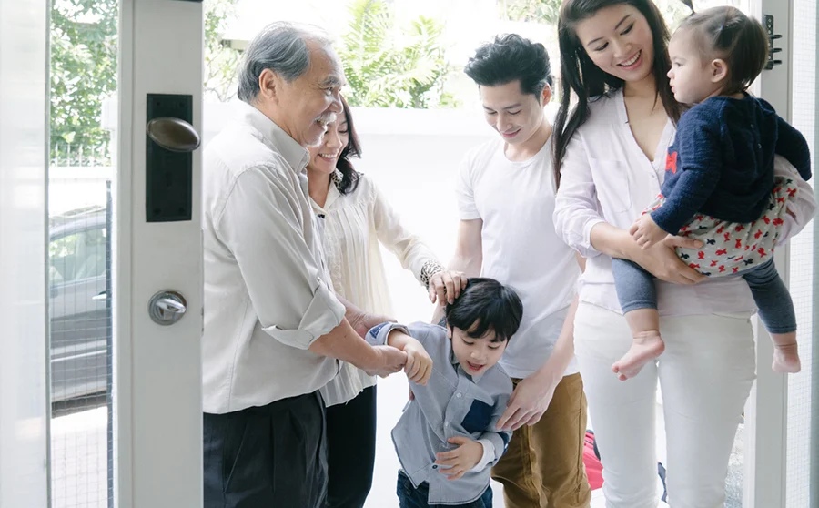 Young family welcoming grandparents into their home