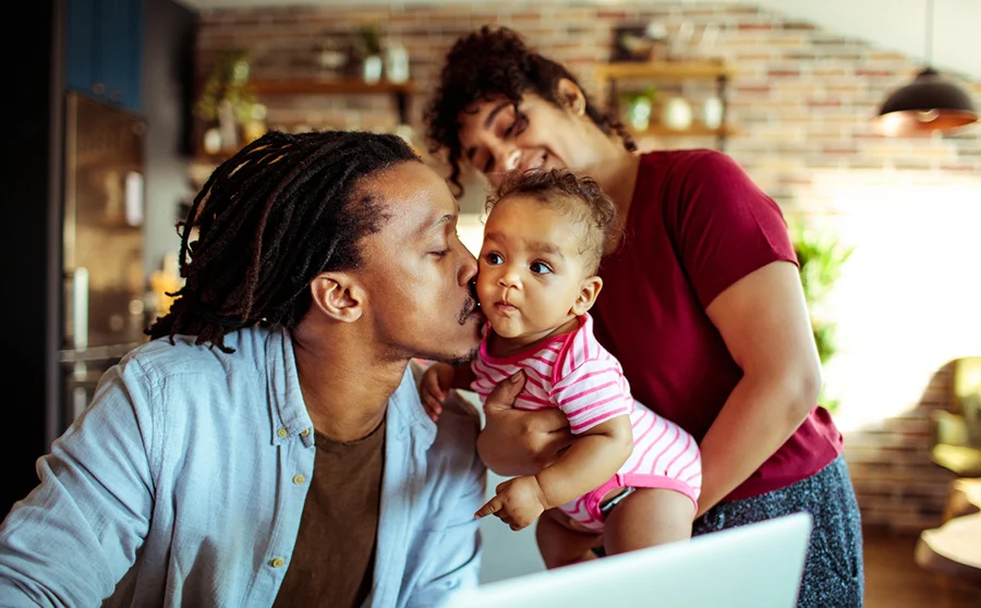 Young family at home caring for baby