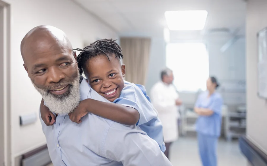 Father giving piggyback to son in hospital.